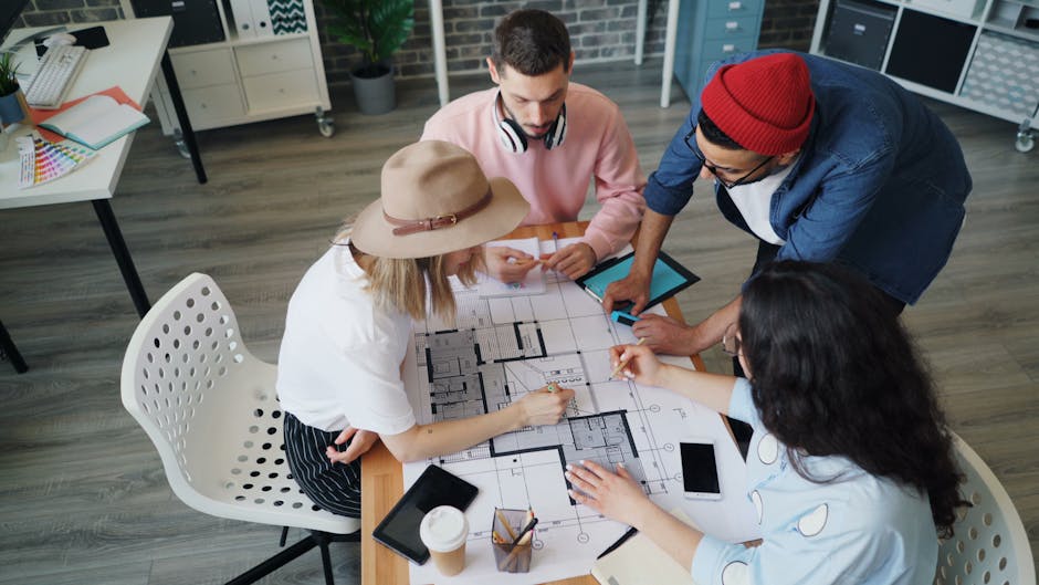 Group of diverse adults collaborating on architectural plans in modern office.